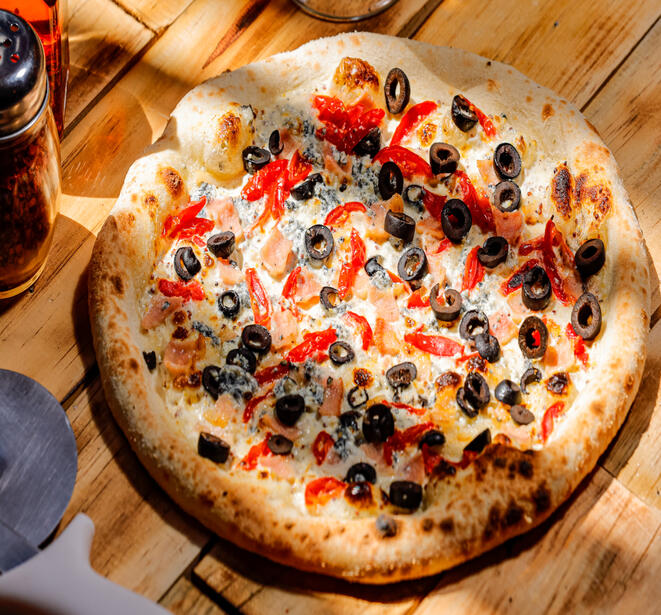 Caprina Cream sauce (homemade with pepper and grain mustard), goat chees, cherry toamtoes, bacon and black olives